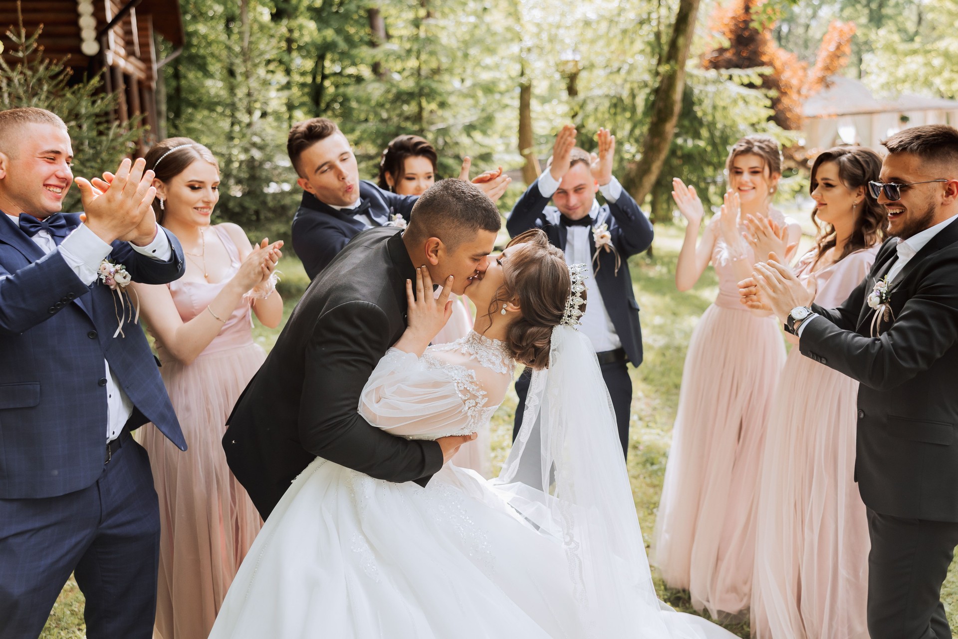 full-length portrait of the newlyweds and their friends at the wedding. The bride and groom with bridesmaids and friends of the groom are having fun and rejoicing at the wedding.