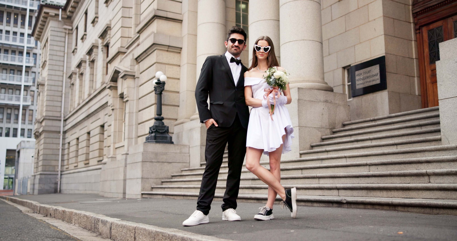 Wedding, city and portrait on street at courthouse with bride, love and bouquet for celebration. Suit, urban and marriage at event for commitment, loyalty and trust with romance for ceremony outdoor